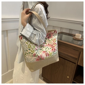 Detail of floral printed tote bag featuring natural jute texture and beige straps