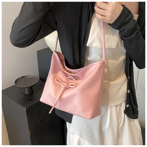 Gros plan du sac seau rose avec un nœud décoratif et une texture en cuir élégante