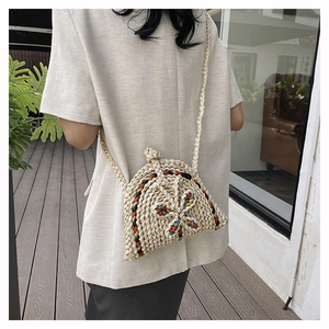 Détail d'un sac bandoulière en paille tissé main avec des motifs papillons colorés
