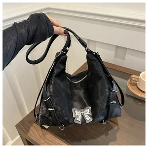 Détail du sac cabas en cuir vintage noir avec nœud argenté et sangles réglables