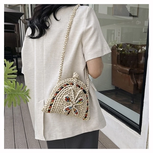 Détail du sac bandoulière tissé à la main en forme de coquille avec accents colorés