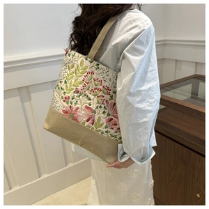 Detailed side view of a floral canvas tote bag on model for casual everyday wear