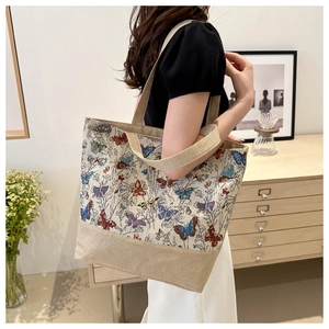 Detail of vintage butterfly embroidery on large canvas tote bag with shoulder strap