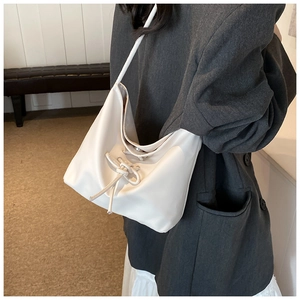Vue détaillée d'un sac cabas blanc en cuir avec un nœud décoratif à cordon réglable