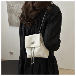 Detailansicht der weißen Schmetterling-Tasche mit Silberverschluss und Kettenfransen