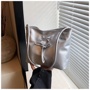 Détail du sac cabas argenté métallisé avec nœuds croisés élégants et cuir synthétique