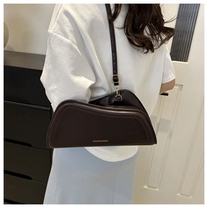 Detail view of a dark brown geometric leather bag with gold FASHION & BAGS lettering