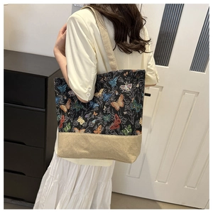 Detail of vintage tote bag featuring colorful butterfly embroidery and canvas texture
