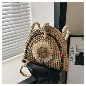 Détail d'un sac en paille tressé à la main avec marguerite 3D et bandoulière tissée