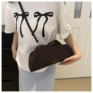 Detail view of coffee brown asymmetrical leather bag with golden FASHION & BAGS logo