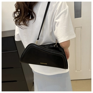 Detailed side view of black leather crescent bag with golden FASHION & BAGS lettering