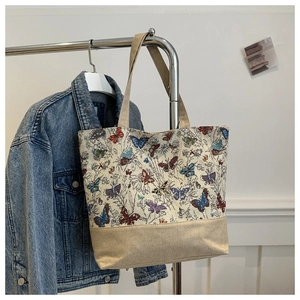 Macro detail of butterfly jacquard fabric and durable linen splicing on a large tote bag