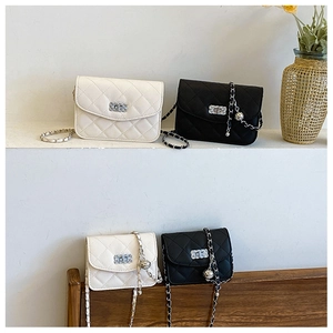 Détails de motif matelassé et chaîne à boule dorée sur sacs à rabat noir et blanc