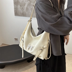 Sac à bandoulière crème minimaliste avec boucle noeud argentée pour femmes de style moderne