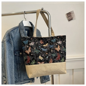 Detail view of large tote bag featuring colorful butterfly jacquard and canvas stitching