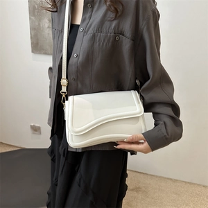Minimalist white crossbody bag with scalloped flap and gold hardware for women