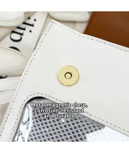 Detailaufnahme des goldenen Magnetverschlusses am weißen Lederrucksack mit PVC-Fenster