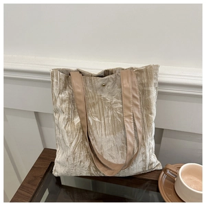Detailed macro view of the velvet tote bag embossed leaf texture and brown leather strap