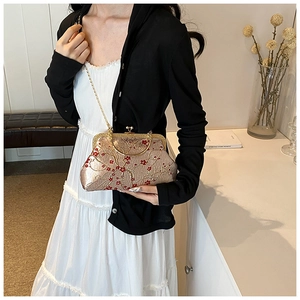 Detail of vintage champagne silk purse with elegant red plum blossom embroidery