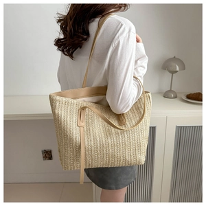 Detail showing the fine vertical woven texture and soft handles of the beige tote bag