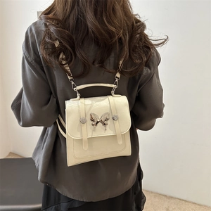 Fashionable cream white PU leather backpack with elegant silver butterfly metal buckle detail