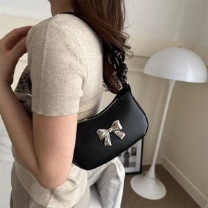 Chic black crescent underarm bag with large silver metal bow and knotted shoulder strap