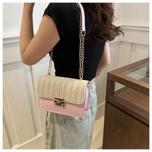 Detail of pink leather and straw crossbody bag with golden chain and metal lock