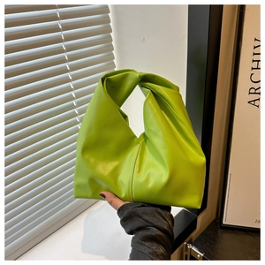 Detail of lime green ruched dumpling bag with a unique twisted knot handle design