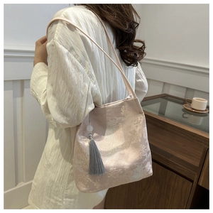 Dettaglio borsa in broccato rosa con ricami floreali argentati e nappa grigia fine