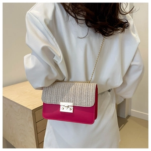 Detail of contrast straw crossbody bag with fuchsia leather and gold chain strap