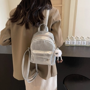 Sleek silver metallic backpack with pleated texture and plush charm for college students