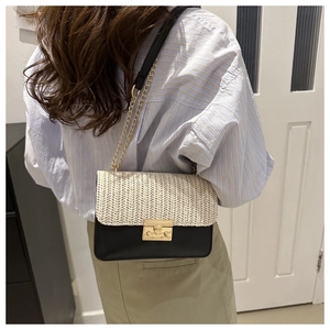 Detail view of the woven straw texture and gold clasp on this chic crossbody bag