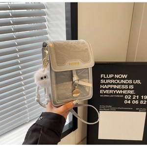 Detail of silver-grey pleated leather crossbody bag with a white fluffy ball charm