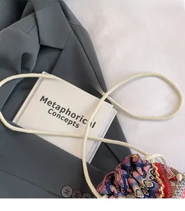 Détail d'un sac seau tissé coloré avec une bandoulière épaisse et cordon de serrage