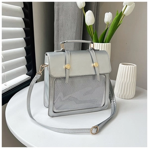 Detailansicht der silbernen Kunstledertasche mit Mesh-Design und goldfarbenen Schnallen