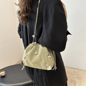 Chic pale green cloud bucket bag with silver butterfly accents and chain strap