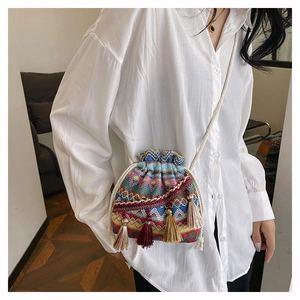 Sac seau tissé ethnique aux motifs géométriques colorés et détails de longs pompons