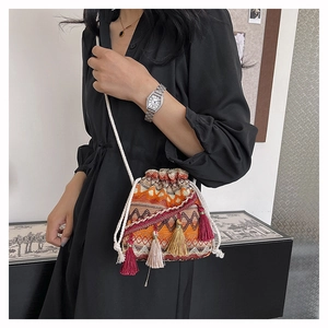 Détails de texture du sac seau bohème tissé avec glands colorés et bandoulière corde