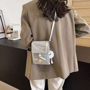 Chic silver crossbody bag with metallic crinkled texture and cute plush pendant