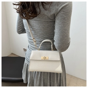 Vue détaillée du sac bandoulière blanc motif crocodile avec fermoir tournant doré au dos