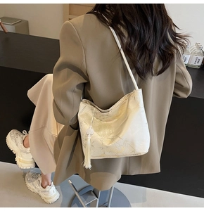 Detail einer beigen Stofftasche im China-Stil mit Jacquard-Bambusmuster und Seidenquaste