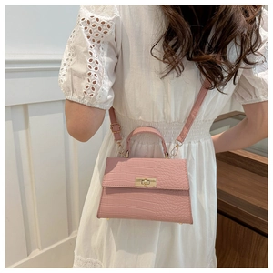 Détail du petit sac carré rose effet crocodile avec poignée et fermoir tournant doré