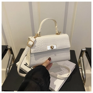 Gros plan de la texture crocodile blanche sur le sac à main avec fermoir doré
