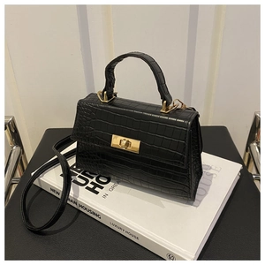 Détail du sac à bandoulière noir motif crocodile avec fermoir rotatif en métal doré