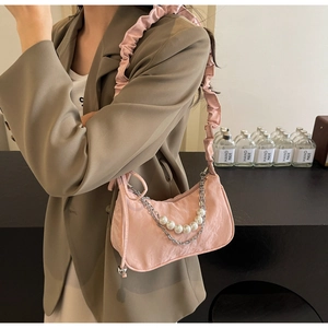 Détail du sac à main plissé rose avec bandoulière élégante en perles et chaîne argentée
