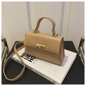 Vue détaillée d'un sac beige effet crocodile avec fermoir rotatif doré et anse courte
