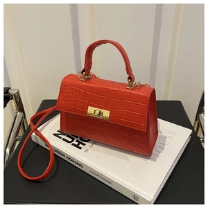 Détail du sac à main rouge en cuir à motif crocodile avec fermoir rotatif en métal doré