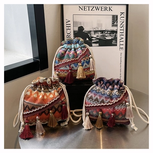 Détails de sacs seaux tissés bohèmes avec motifs géométriques et pompons colorés