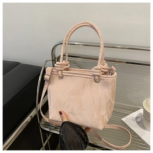 Détail du sac seau rose plissé en PU avec poignée à nœud et bandoulière réglable, style moderne
