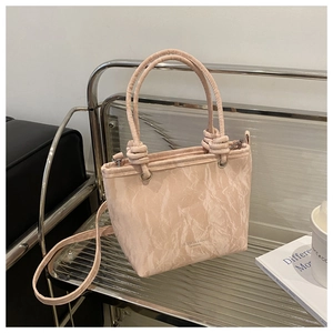 Vue détaillée du sac cabas en cuir rose avec texture froissée marbrée et nœuds de poignée